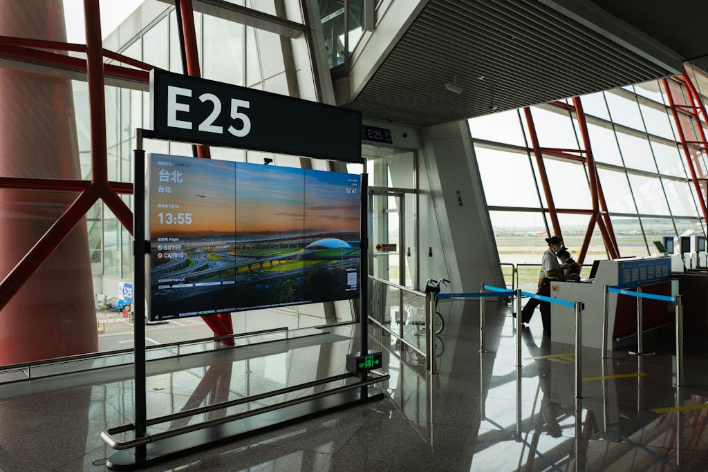 A view of a modern airport terminal showcasing Gate E25 with a flight display board.