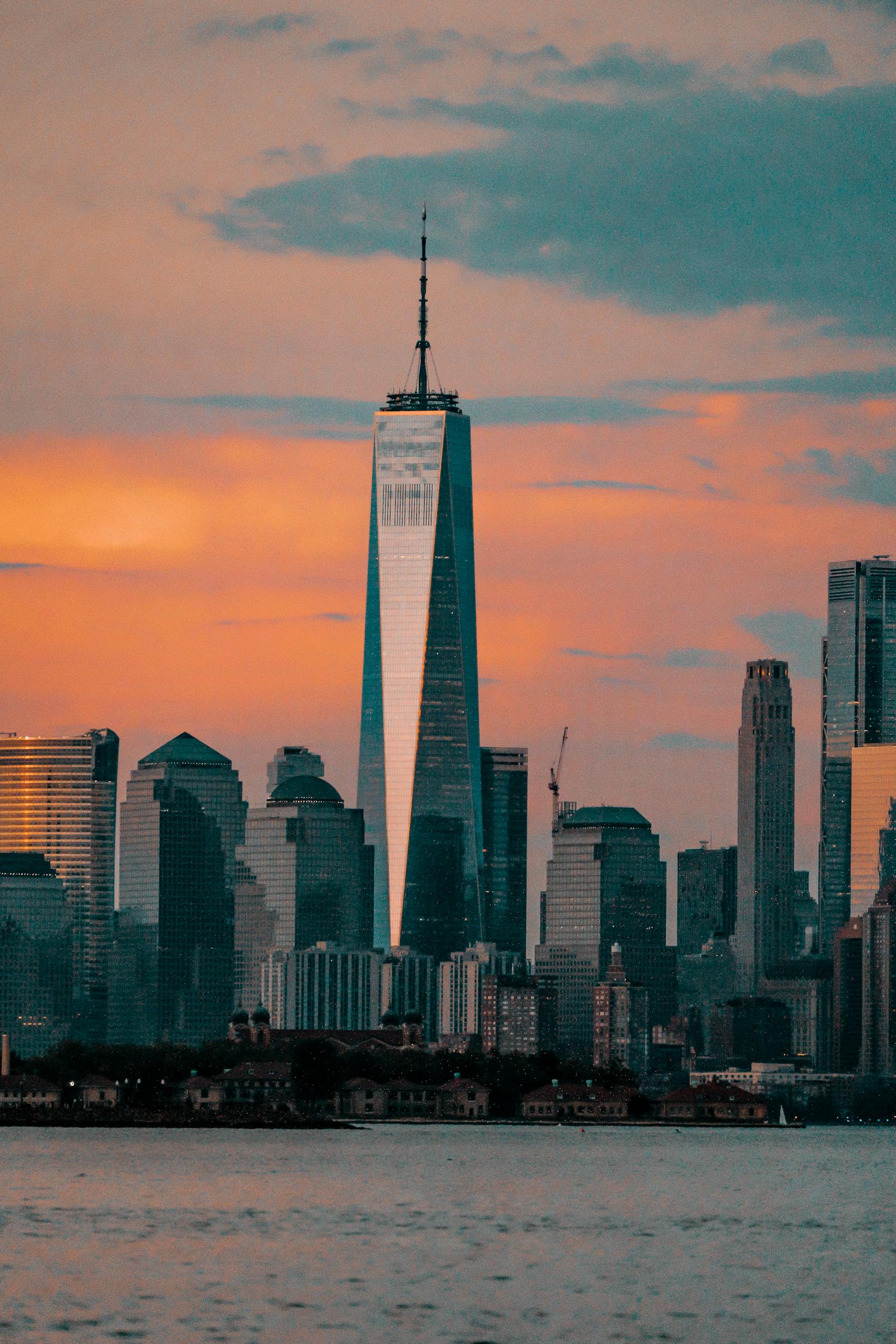 Silhouette of One World Trade Center during a vibrant New York City sunset.
