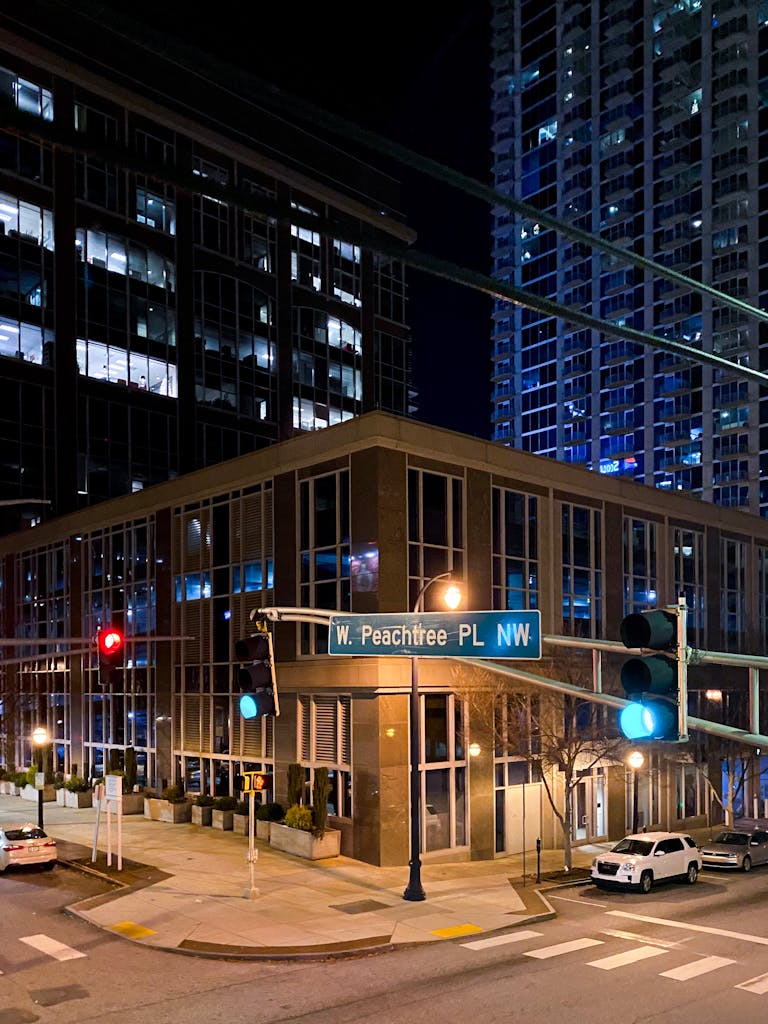 A bustling street scene in downtown Atlanta at night, showcasing modern architecture and urban life.