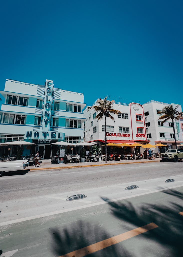 Colorful scene capturing Miami Beach's historic Ocean Drive with palm-lined street and iconic Art Deco hotels.