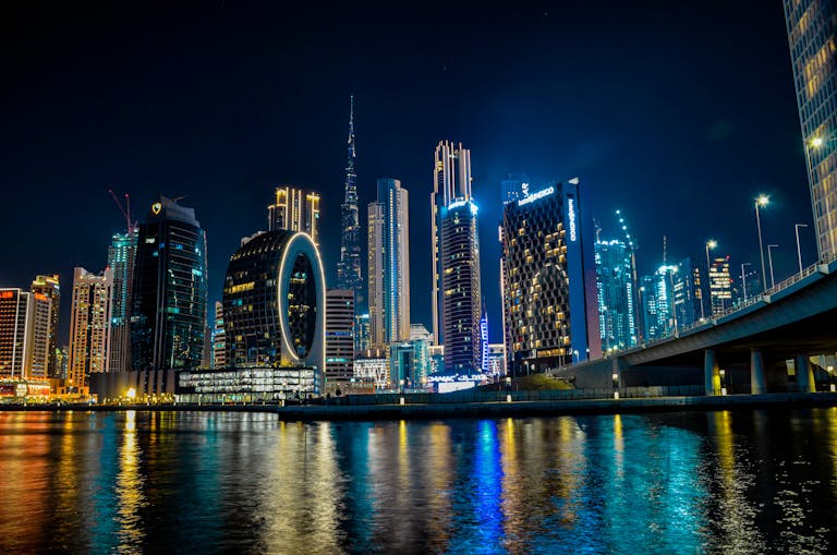 High-rise buildings of Dubai glittering at night, with Burj Khalifa illuminated in the skyline.