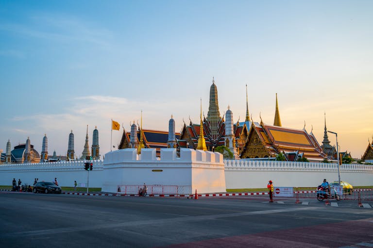 Stunning view of the Grand Palace in Bangkok with its traditional architecture during sunset.