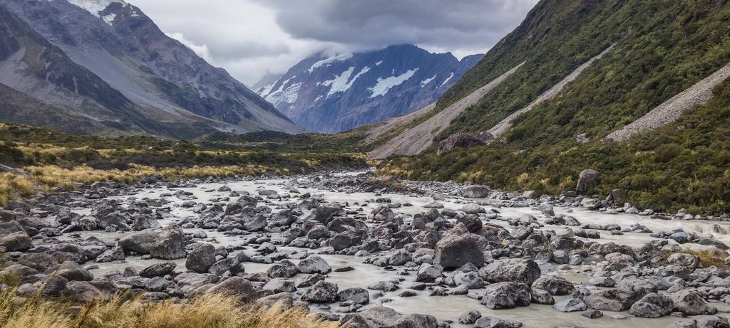 Breathtaking mountain valley with rocky river and lush green surroundings.